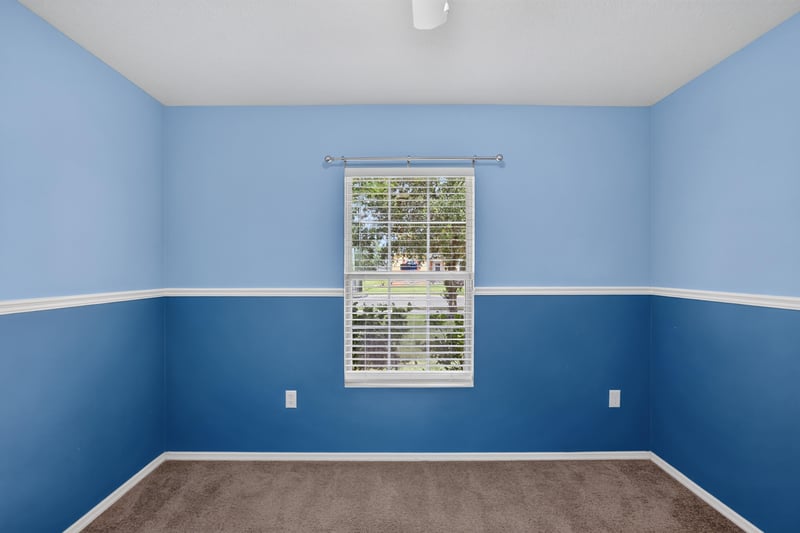 Empty bedroom with blue walls and window at 7545 Lirope St, Jacksonville, FL 32244