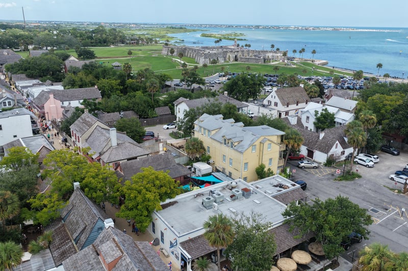 Aerial view of downtown rooftops with the fort and bay beyond in St. Augustine, FL