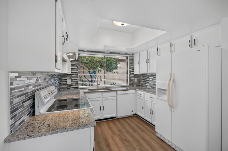 Kitchen with white cabinets and tile backsplash at 3407 Fairbanks Grant Rd N, Jacksonville, FL 32223
