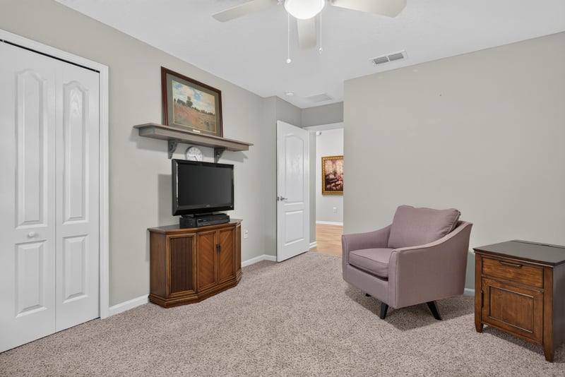 Bedroom with wood furniture and armchair at 4319 Green River Pl, Middleburg, FL 32068