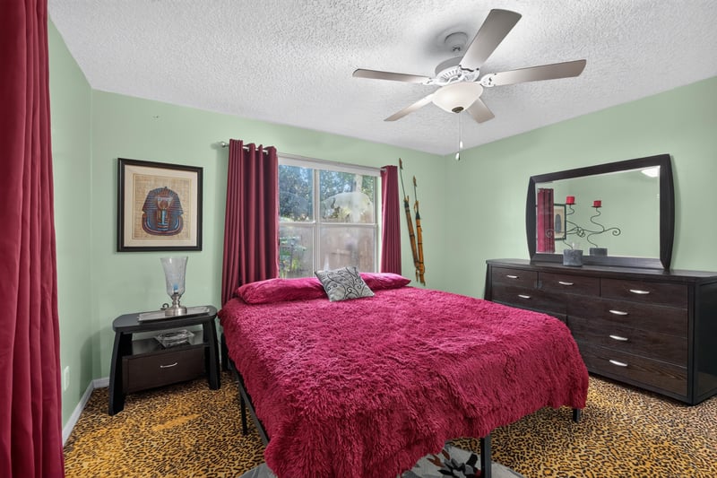 Bedroom with red bedding and dresser at 1346 Gately Ct, Jacksonville, FL 32225