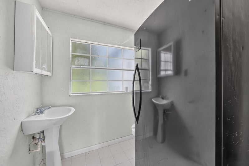 Bathroom with pedestal sink and mirrored cabinet at 1173 US-17, Satsuma, FL 32189