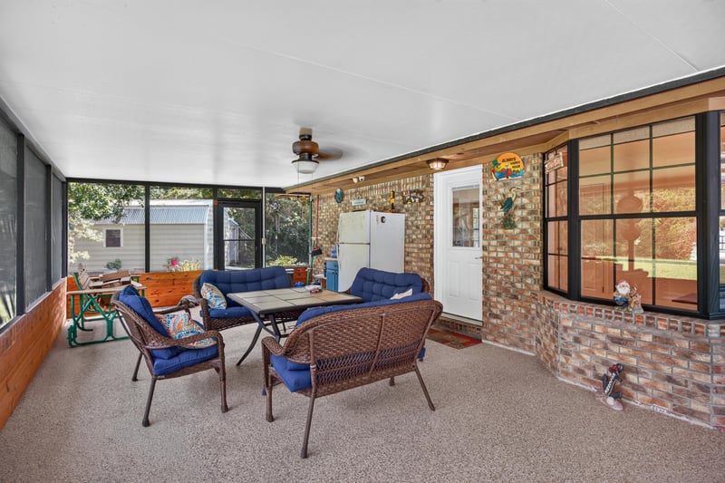 Screened porch seating area at 2435 Range Line Rd, Middleburg, FL