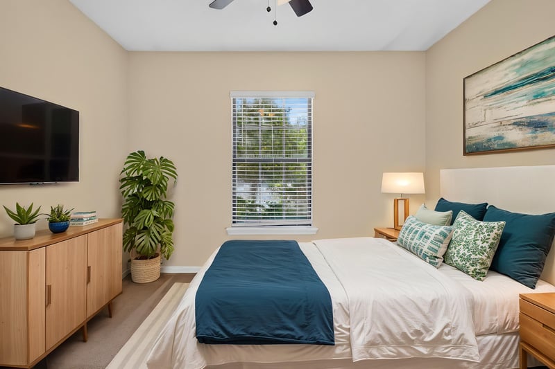 Primary bedroom virtually staged with bed and TV at 353 Redwood Ln