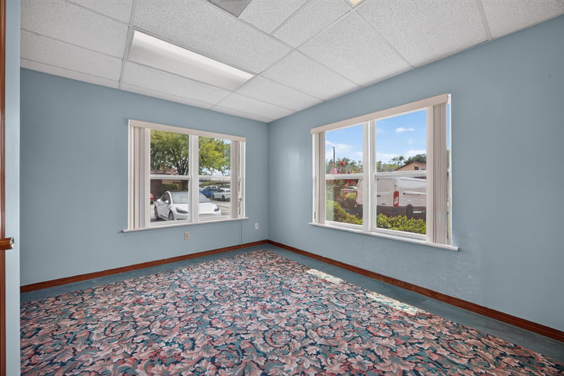 Corner room with floral carpet and two windows at 1543 Kingsley Ave #19, Orange Park, FL 32073