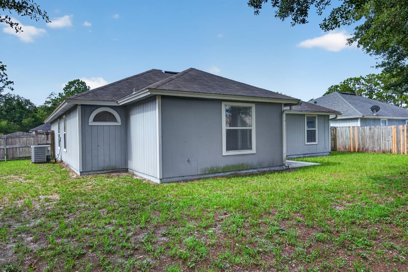 Side exterior with AC unit and fenced yard at 8519 Blazing Star Ct, Jacksonville, FL 32210