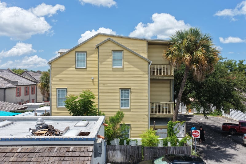 Yellow multi-story building exterior with balconies and palm trees at 29 Cuna St, St. Augustine, FL 32084