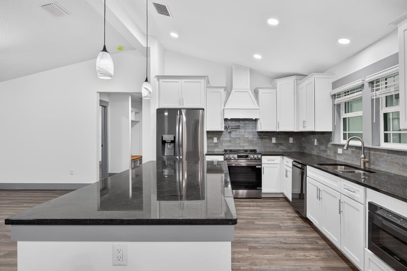 Kitchen island with black countertop at 4800 Acacia St, Middleburg, FL 32068
