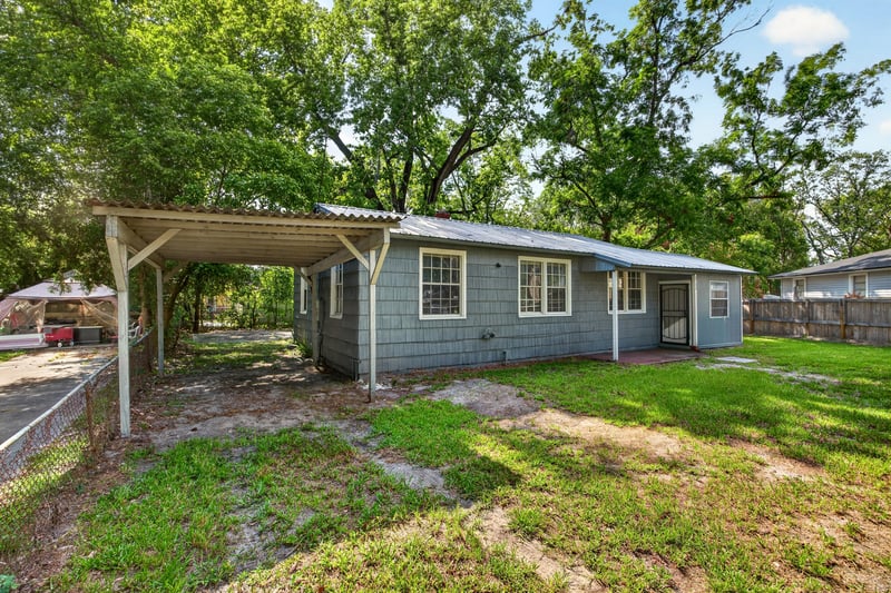 Side yard view with carport and gravel drive at 2132 Allandale Cir W, Jacksonville, FL
