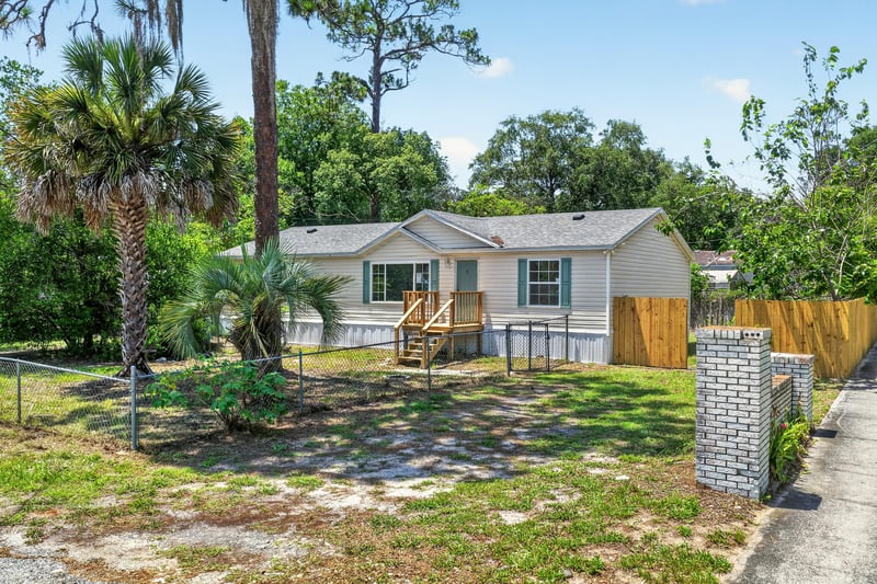 Front exterior with wood staircase and trees at 7603 Coach Park Dr, Jacksonville, FL 32244