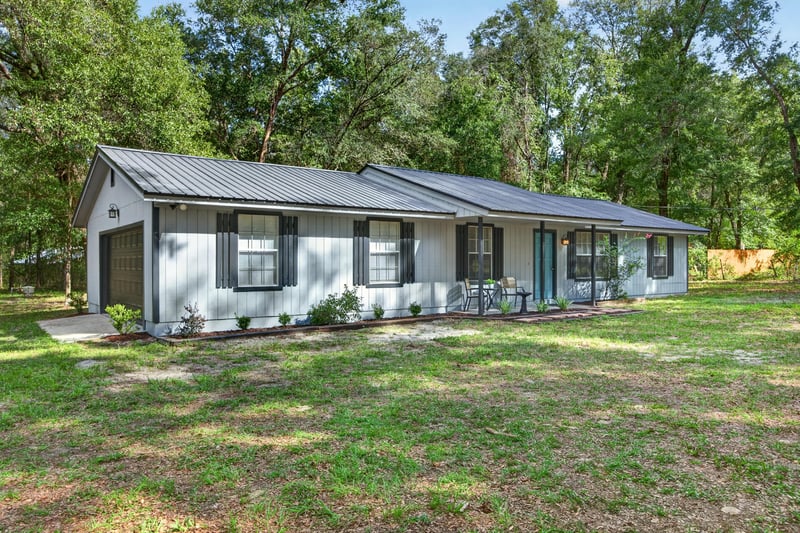 Front exterior view with black shutters and wide lawn at 2829 Blackberry Ave