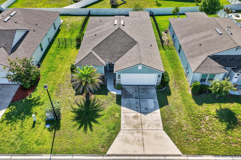Aerial front view at day-to-dusk showing driveway and roofline at 589 Seville Pkwy, St. Augustine, FL