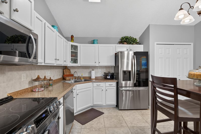 Kitchen with white cabinets and stainless range at 3067 Wavering Ln, Middleburg, FL 32068