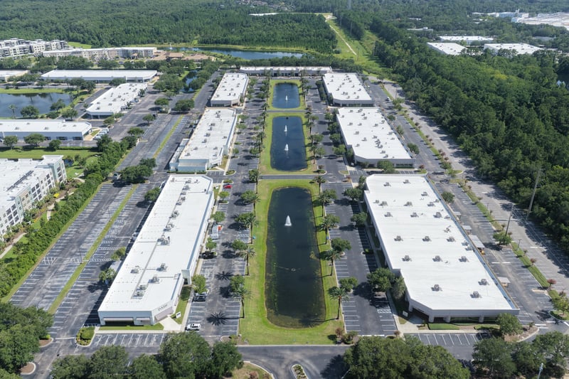 Aerial view of office park rooflines and central pond at 10550 Deerwood Park Blvd, Jacksonville, FL 32256