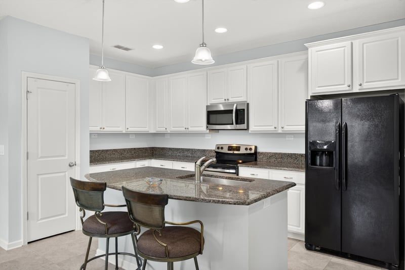 Kitchen island with bar stools at 2378 Caney Oaks Dr, Jacksonville, FL