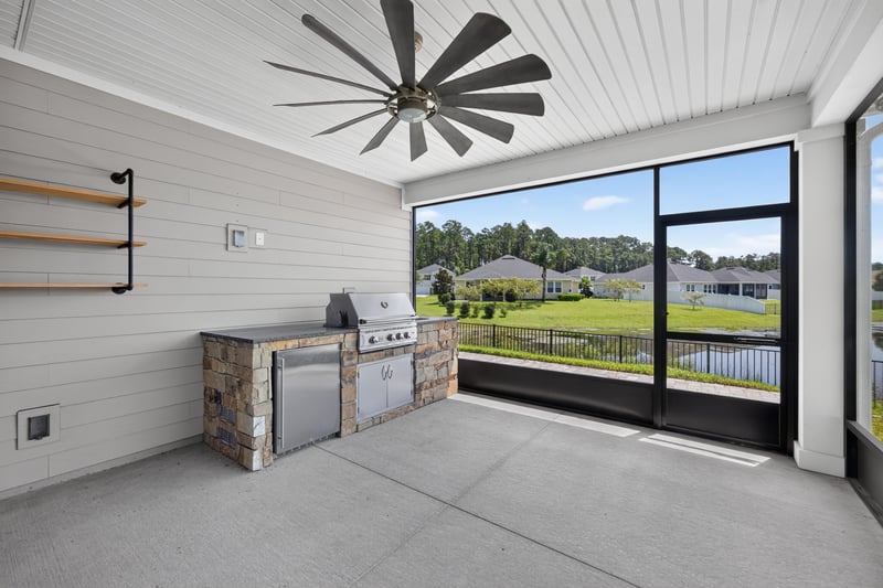 Screened lanai with outdoor kitchen and ceiling fan at 855 Flach Dr, St. Johns, FL