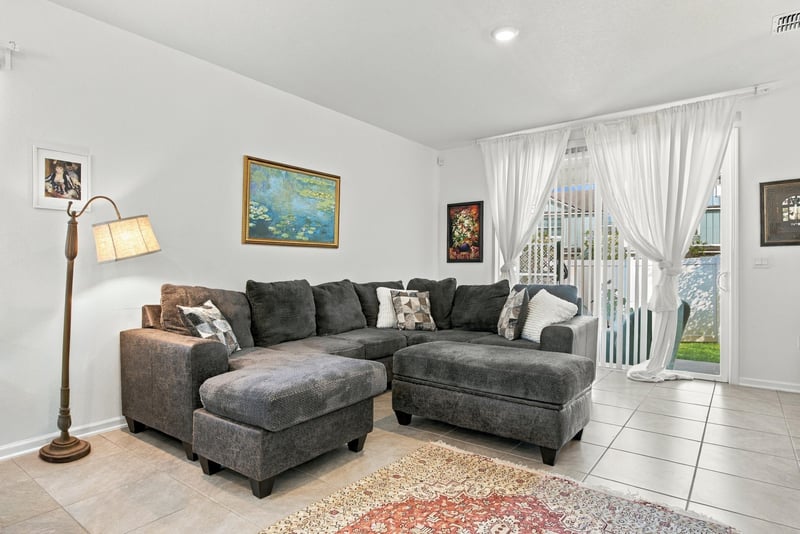 Living room with sectional sofa and sliding glass door at 8359 Zenith Cir, Jacksonville, FL 32256